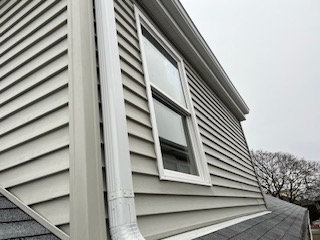 a newly installed window with white trim and black detailing